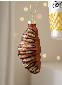 Dettaglio di un addobbo natalizio a forma di croissant con glitter dorati e trama bronzo