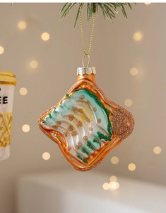 Dettaglio di un addobbo natalizio a forma di toast con glitter e laccio dorato