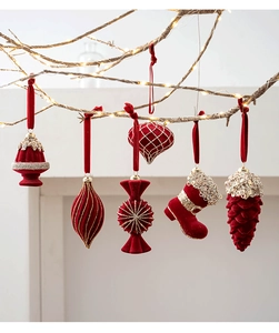 Detailed view of six burgundy flocked Christmas ornaments hanging with warm LED lights