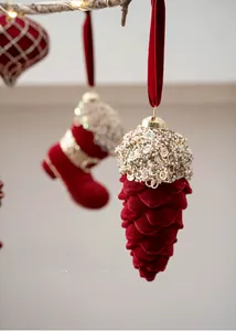 Detail of burgundy flocked Christmas ornaments with gold beads and pinecone shapes