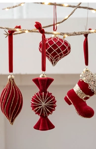Detail of burgundy flocked Christmas ornaments with gold glitter on lighted branches