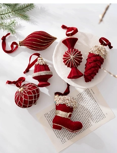 Detail of burgundy flocked Christmas ornaments with gold glitter accents and velvet ribbons