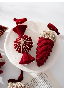 Close-up of luxury burgundy velvet Christmas ornaments with gold glitter and sequins
