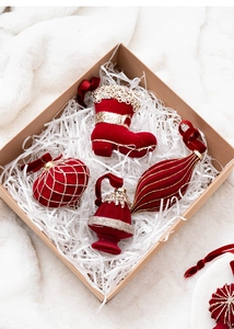 Macro detail of burgundy flocked Christmas ornaments with gold glitter in a gift box