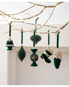 Close-up of velvet dark green Christmas ornaments with gold stitching and LED lights