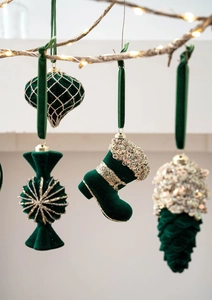 Detail of emerald green flocked Christmas ornaments with gold sequins on festive branches