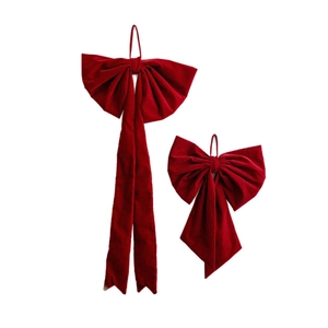 Large red velvet Christmas bow with long streamers for holiday window and tree decoration