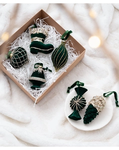 Detail of dark green velvet Christmas ornaments with glitter accents and plush textures