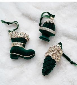 Close-up of emerald green velvet Christmas ornaments with gold glitter details