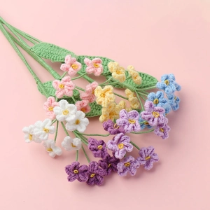 Macro detail of colorful hand-knitted forget-me-not crochet flowers with soft texture