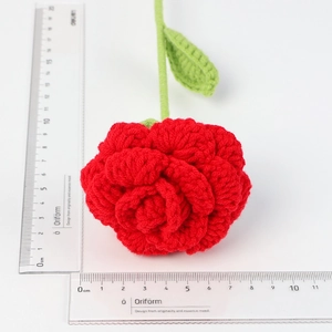 Detailed top view of handmade crochet red rose with measurements on a white background