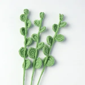 Macro shot of three handcrafted green crochet eucalyptus leaves for home decor