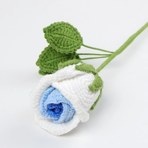 Detailed macro view of handmade crochet rose with blue and white gradient layered petals
