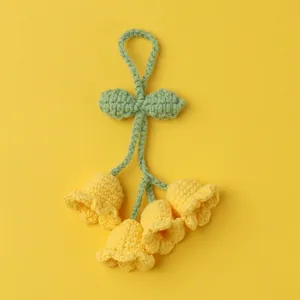 Handmade crochet lily of the valley keychain with four yellow flowers and green leaves