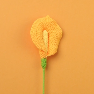 Détail macro de calla lily tricoté main montrant la texture du fil orange et la tige