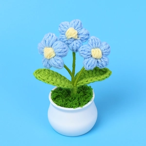 Primer plano de flores de ganchillo azules en maceta blanca para decoración