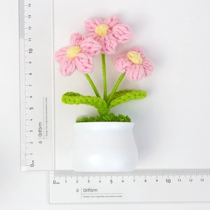 Detalle de flor rosa de ganchillo hecha a mano en maceta blanca con medida de 13,5 cm