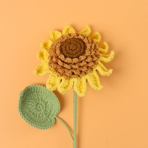 Handcrafted crochet sunflower with yellow petals and green leaf for home decoration