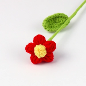 Dettaglio di fiore all'uncinetto fatto a mano con petali rossi per decorazioni fai-da-te