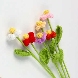 Dettaglio di cinque fiori colorati fatti a mano all'uncinetto con texture in filato