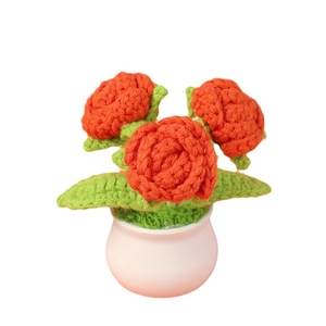 Handmade crochet potted orange roses with green leaves in a small decorative white pot