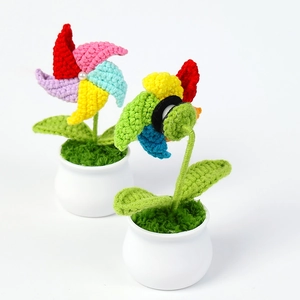 Handmade crochet colorful windmill potted plants with green leaves in white ceramic pots