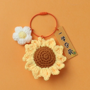 Close-up of hand-knitted sunflower keychain with orange wire ring and acrylic tag