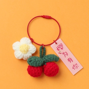 Detailed knit texture of handmade crochet cherry and flower keychain with wire ring