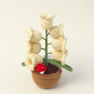 Detail of hand-knitted lily of the valley lamp with crochet textures and a tiny mushroom