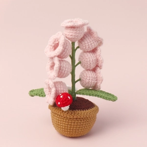 Macro detail of hand-crocheted lily of the valley lamp with a cute mini red mushroom