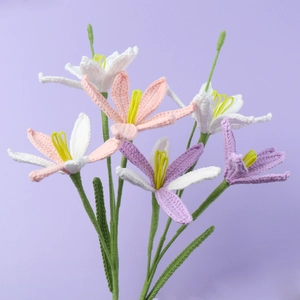 Macro detail of handmade crochet zephyranthes flower with delicate pink petals and green stem