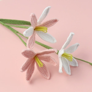 Detail of handmade crochet lilies showing intricate pink and white yarn textures