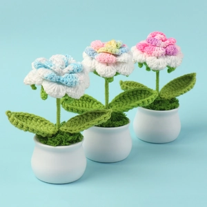 Detailed macro view of three handmade crochet rose potted plants in white ceramic pots