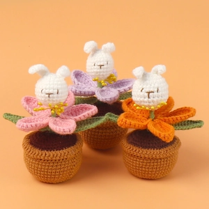 Detailed view of handmade crochet bunny flower pots in pink, purple, and orange colors