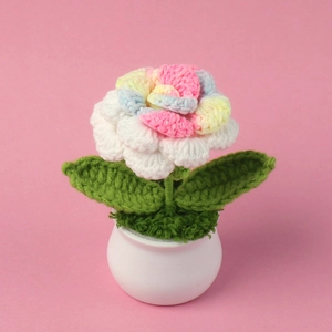 Close-up of handmade crochet rose plant in a white pot for desktop decoration