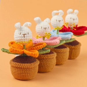 Close-up of four handmade crochet rabbit flower potted plants in various vibrant colors