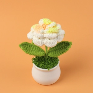 Detailed view of handmade crochet rose plant with gradient petals in a white ceramic pot