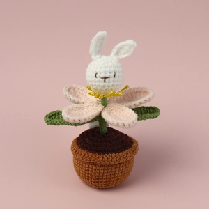 Close-up of hand-knitted bunny flower potted plant showing intricate yarn texture and stitches