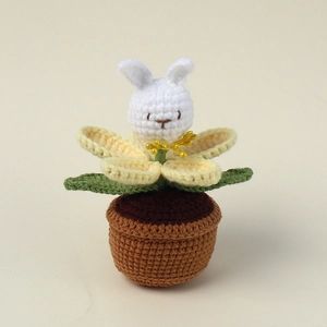 Detailed macro shot of handmade crochet white rabbit flower in a knitted brown pot