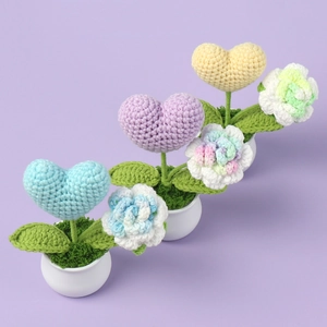 Handmade crochet mini heart potted plants on light purple background for desk decoration