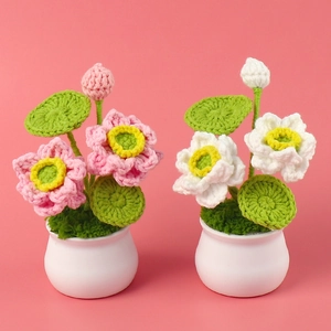 Handmade crochet lotus potted plants in pink and white with ceramic base on pink background