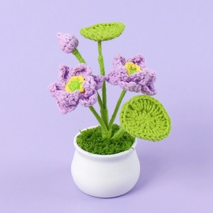 Macro detail of handmade crochet lotus in white ceramic pot with purple petals