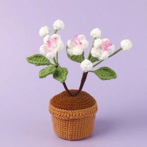 Plante en pot au crochet faite main avec fleurs blanches et détails roses pour déco de bureau