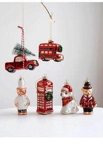Detailed close-up of festive blown glass ornaments including red bus and teddy bear motifs