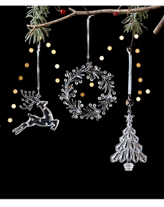 Macro detail of transparent Christmas ornaments including reindeer, wreath, and tree