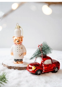 Detail of Christmas glass ornaments featuring a Sacher chef bear and a vintage red car
