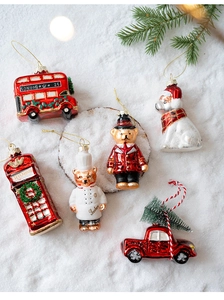Detail of Christmas glass ornaments set with London bus and teddy bear in a snowy scene