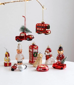 Detailed collection of festive painted glass Christmas ornaments on a lit branch