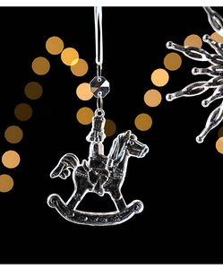 Macro detail of a transparent nutcracker on a rocking horse ornament with gold bokeh