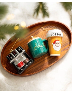 Dettaglio degli ornamenti natalizi a tema caffè con macchina per caffè espresso e tazze